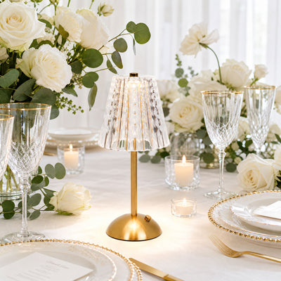 Elegant white rose wedding table setting with gold-accented crystal lamp and glassware