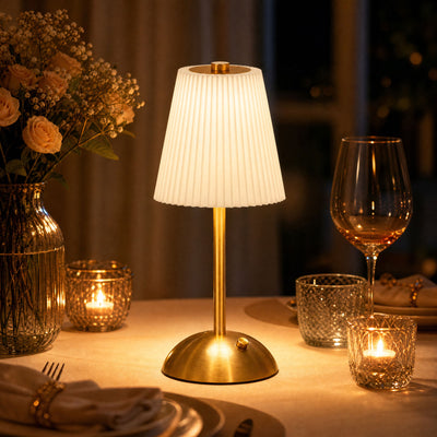 Elegant gold table lamp on a candlelit dinner table with roses and glassware