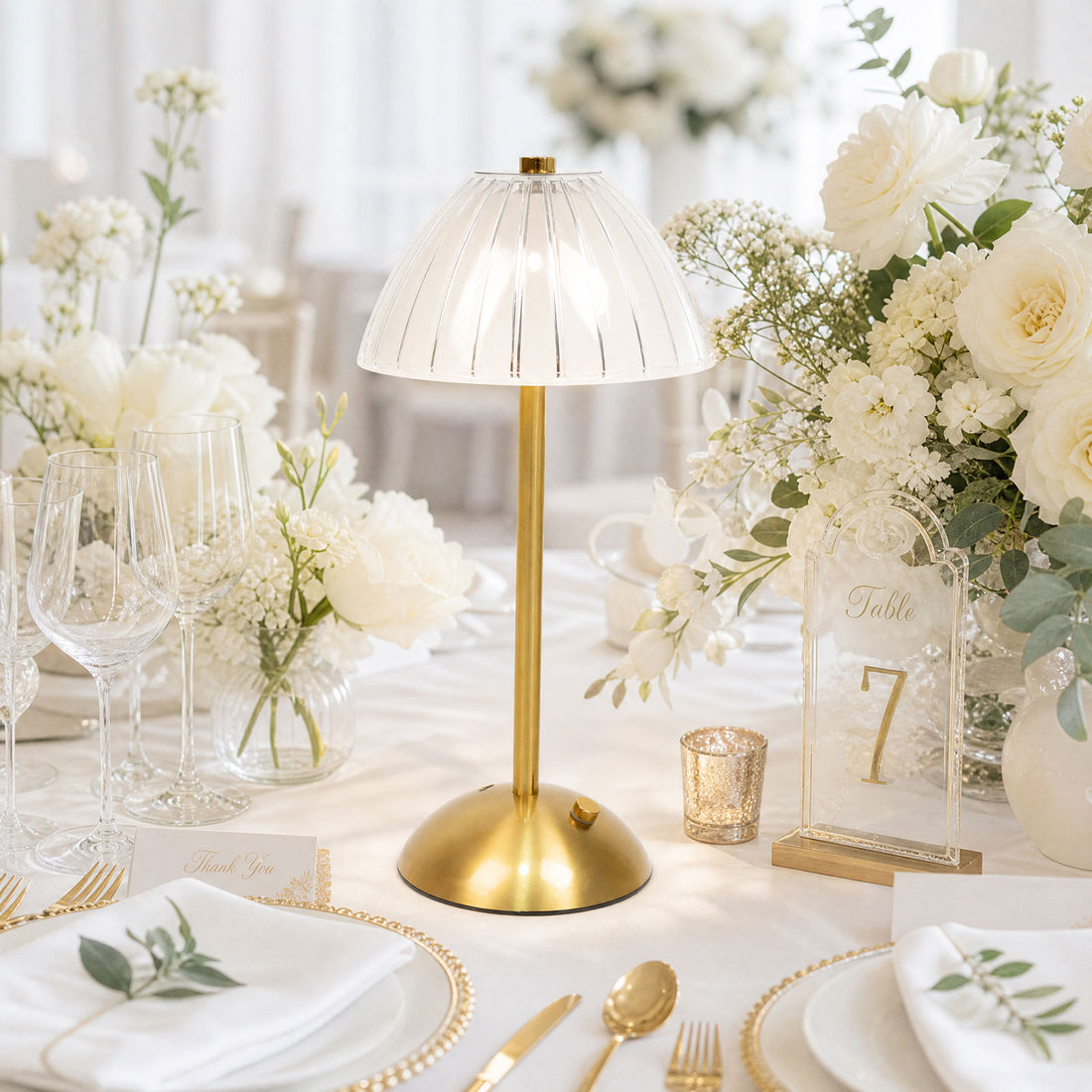 Elegant gold table lamp centerpiece on a white floral wedding table setting