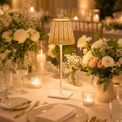 Elegant wedding table setting with flowers, candles, and woven lamp
