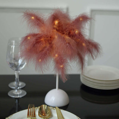 Pink feather table lamp with soft glowing lights, elegant dinner setting.