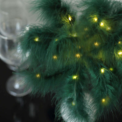 Decorative green plant with warm LED lights on a dark surface.