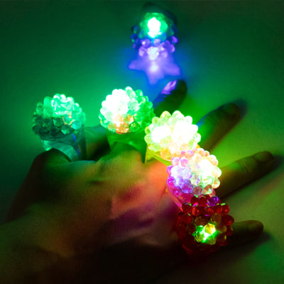 Colorful light-up flower rings on a hand, showcasing vibrant LED designs.