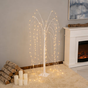 Decorative LED light tree with cascading branches in a cozy indoor setting.