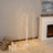 Decorative LED light tree with cascading branches in a cozy indoor setting.