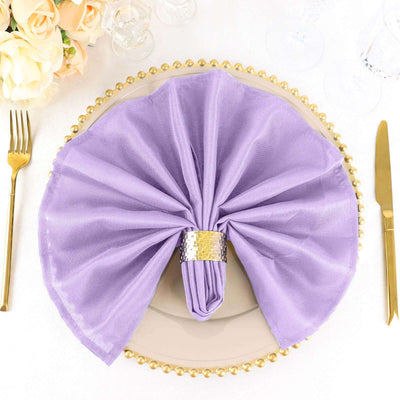 Purple cloth napkin elegantly arranged on a decorative plate with gold accents.