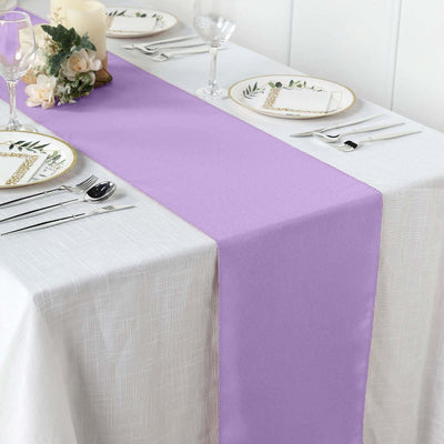 Purple table runner on a white dining table set with elegant dinnerware.