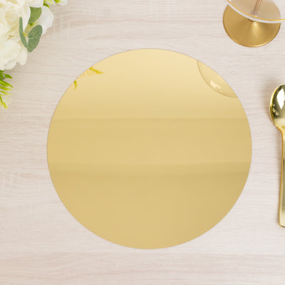 Gold round placemat on a wooden table with cutlery and flowers.