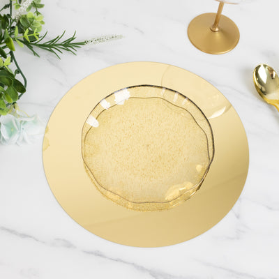 Gold decorative plate with textured design on a marble table.