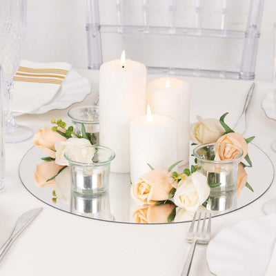 Elegant candle centerpiece with flowers on a mirrored tray.