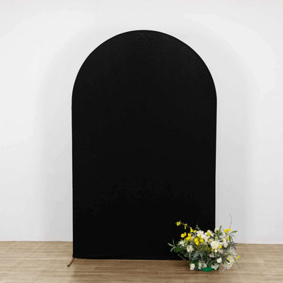 Black arch backdrop with floral arrangement in front.