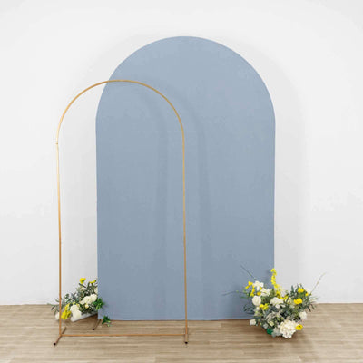 Blue arch backdrop with floral arrangements in a studio setting.