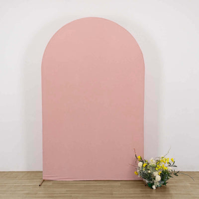 Pink arch backdrop with floral arrangement on the floor.