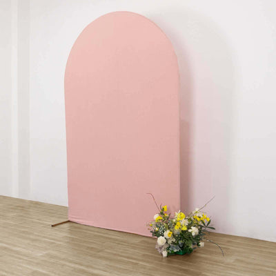 Pink arch backdrop with a bouquet of flowers in front.