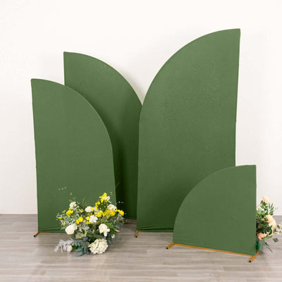 Green fabric backdrops in various shapes with floral arrangement in foreground.