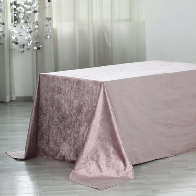 Pink velvet tablecloth draping elegantly over a table in a softly lit room.