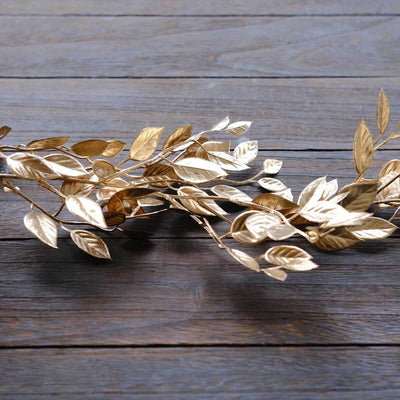 Gold metal leaf garland on wooden surface.