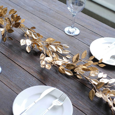 Gold leaf table centerpiece on rustic wooden table setting.