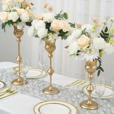 Elegant gold candlesticks with floral arrangements for table decor.