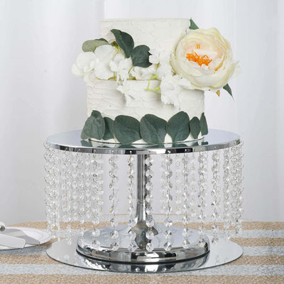 Elegant wedding cake on a decorative crystal cake stand with floral accents.