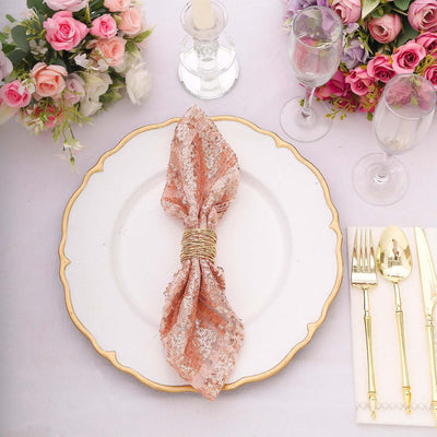 Elegant rose gold napkin tied on a decorative plate at a beautifully set table.