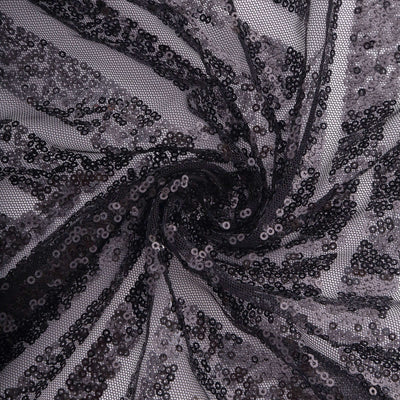 Black sequin fabric in a swirling pattern.