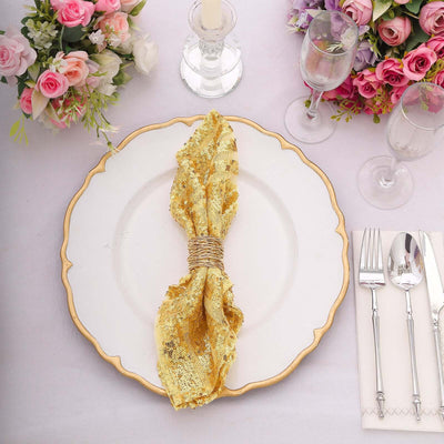 Gold sequin napkin on an elegant dinner plate, surrounded by floral decor.
