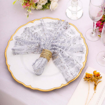 Elegant silver sequined napkin tied with twine on a decorative plate.
