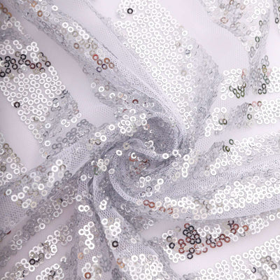 Silver sequin fabric with shimmering sequins in a spiral arrangement.