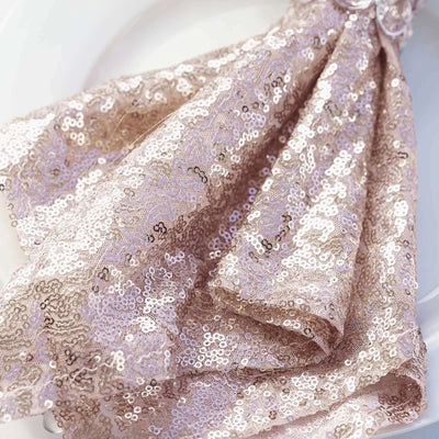 Rose gold sequin napkin elegantly folded on a white plate.