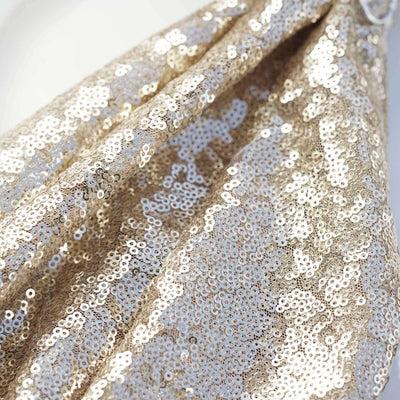 Gold sequin fabric draping elegantly, showcasing its shiny texture.