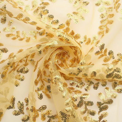 Golden sequin fabric with intricate leaf patterns on a light background.