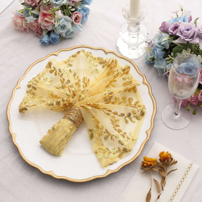 Elegant gold embroidered napkin on decorative plate with floral accents.