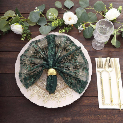 Elegant green embroidered napkin on decorative plate with floral accents.