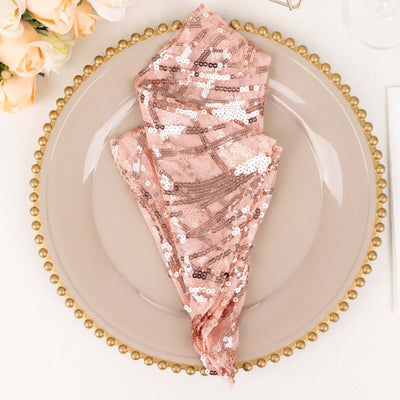 Rose gold sequin napkin elegantly folded on a decorative plate.