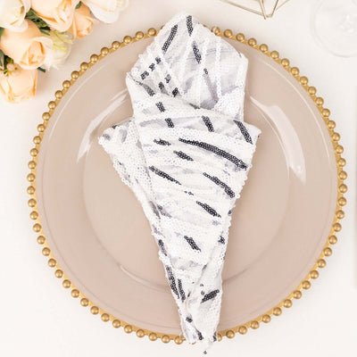 Elegant white and black sequin napkin on a decorative plate.