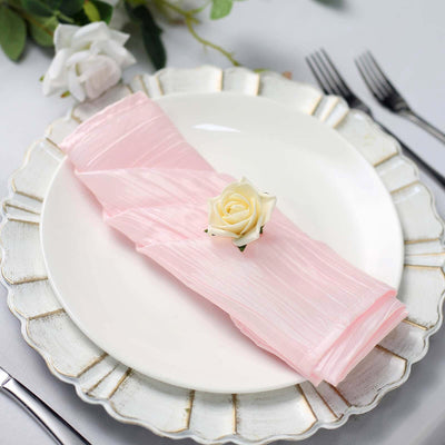 Elegant pink napkin with a white rose on a decorative plate.
