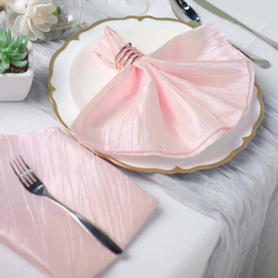 Elegant pink napkin with ring on a decorative plate at a dining table setting.
