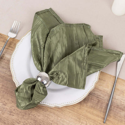 Olive green silk napkin elegantly tied on a decorative plate.