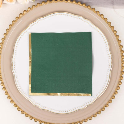 Green napkin with gold foil edge on decorative plate.