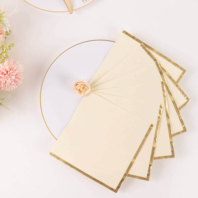 Elegant cream stationery with gold foil edges, arranged on a white plate.