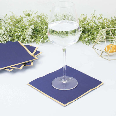 Navy blue paper napkin with gold trim under a wine glass