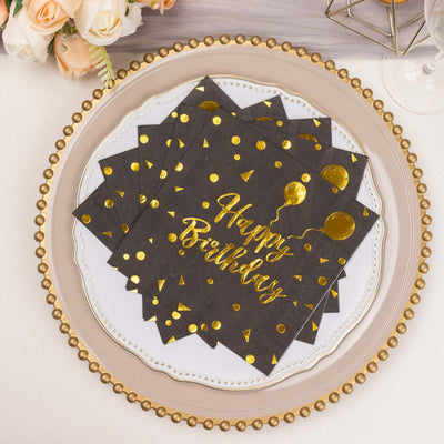 Gold-foil "Happy Birthday" napkins on a decorative plate.