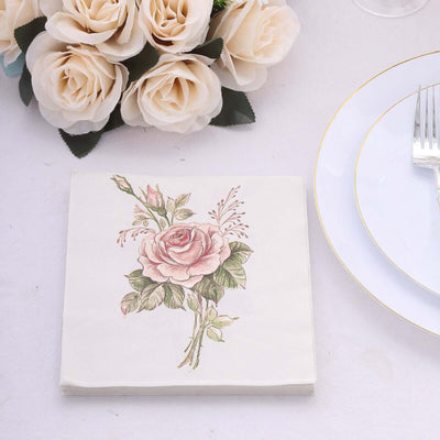 Rose-patterned napkin on a table setting with flowers and plates.