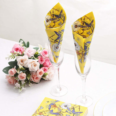 Yellow floral napkins elegantly displayed in champagne glasses with roses.