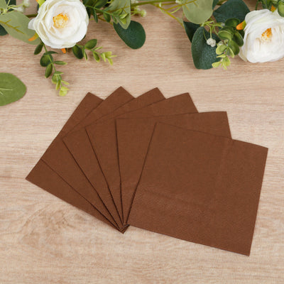 Brown paper napkins stacked on a wooden surface.
