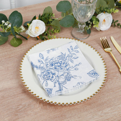 Floral-patterned napkin on an elegant dinner plate with greenery