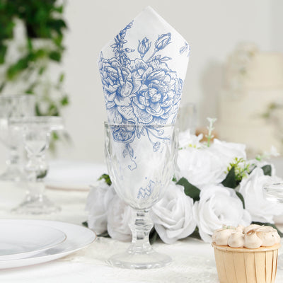 Blue floral patterned napkin in a glass on an elegantly set dining table.