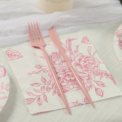 Pink floral napkin with matching cutlery on a textured table setting.
