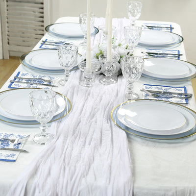 Elegant dining table set with white plates, crystal glassware, and candles.